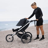 Thule Glide 3 joggingvagn på stranden med barnet i sittdelen, hyr hos Parently